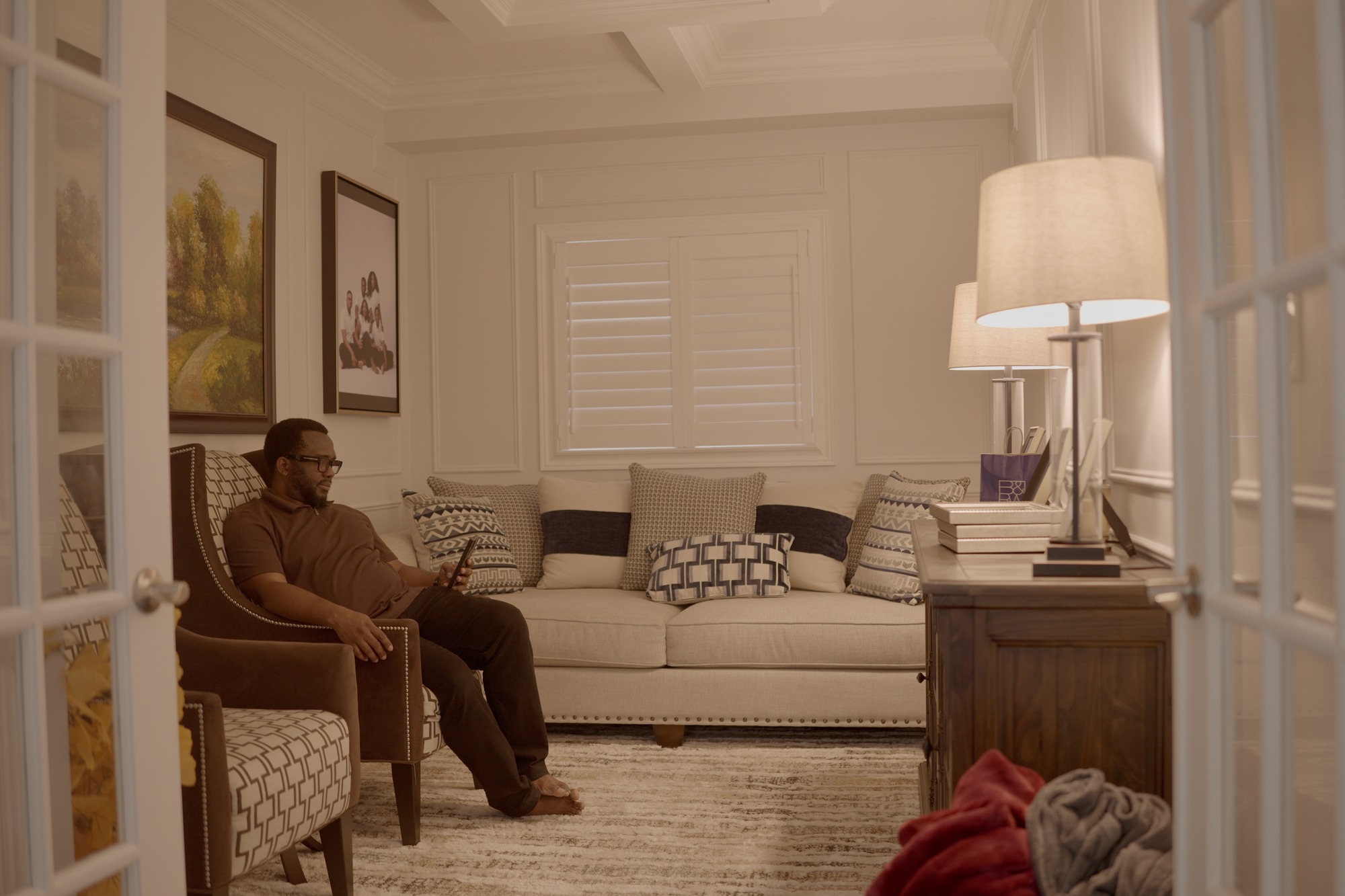 Chima seated in his living room
